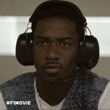 a man wearing headphones and a microphone has #fimovie written on the bottom right