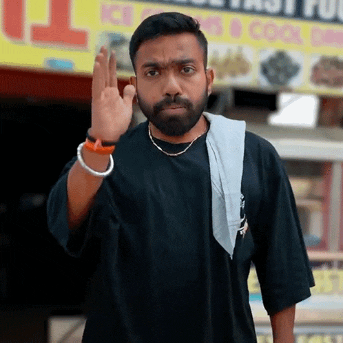 a man with a beard is giving the middle finger in front of a sign that says ice cream