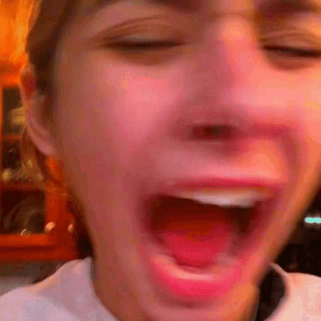 a close up of a woman 's face with her mouth wide open