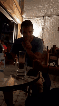 a man is sitting at a table with a bottle of ice cream on it