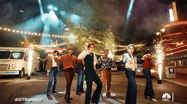 a group of people are dancing in front of a sign that says dynex