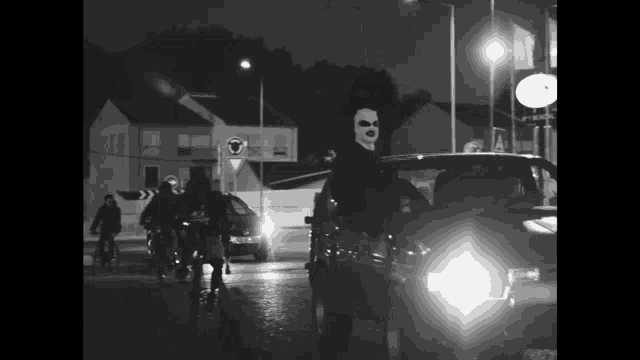 a black and white photo of a group of people riding bikes