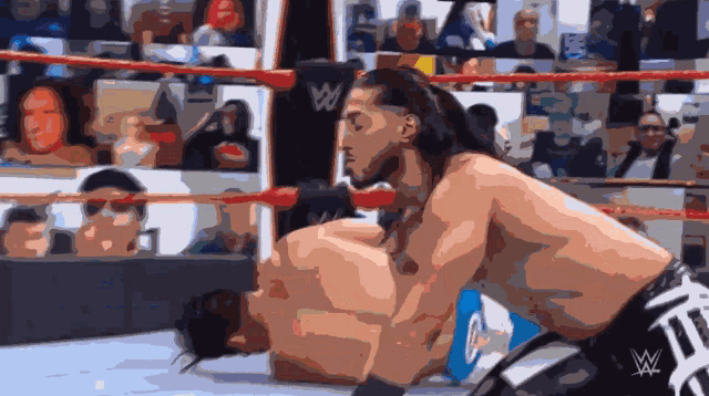 two wrestlers in a wrestling ring with a w logo on the back of their shorts