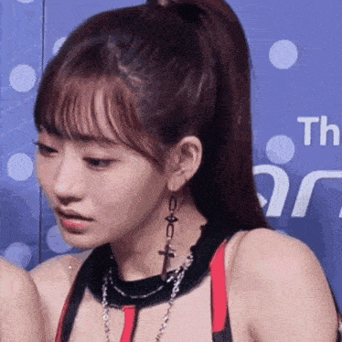 a close up of a woman wearing a ponytail and a necklace