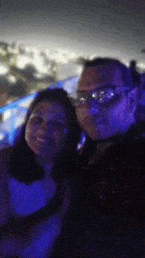 a man and a woman are posing for a picture with a blue background