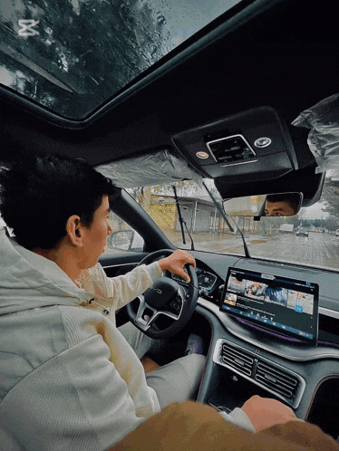 a man is driving a car with a screen that says youtube