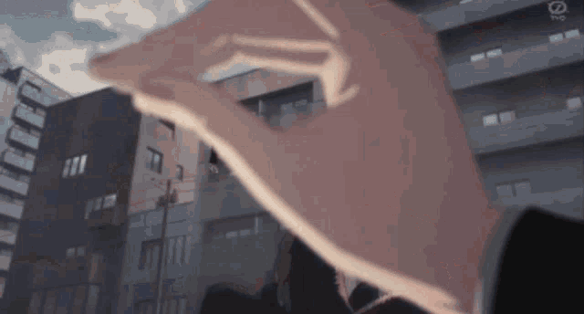 a close up of a person 's hand with a city in the background