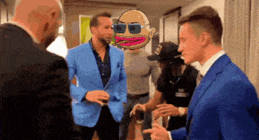a man in a blue suit talks to a man in a black hat