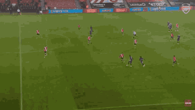 a soccer game is being played on a field with a monster advertisement in the background