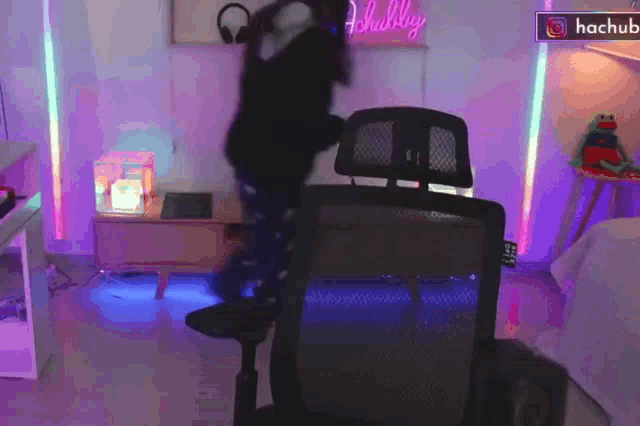 a person is dancing in a room with a hachub sign in the corner