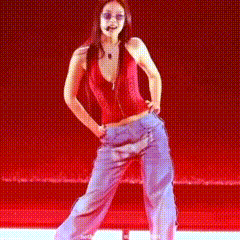 a woman in a red top and blue pants is dancing