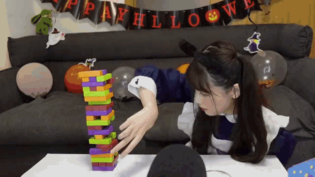 a girl is playing a game with a halloween banner behind her