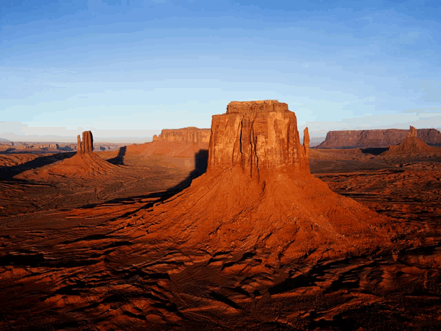 a desert landscape with red rocks and a blue sky