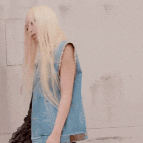a woman with blonde hair is wearing a blue vest