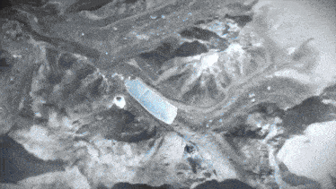 a black and white photo of a mountain with a blue stripe in the middle