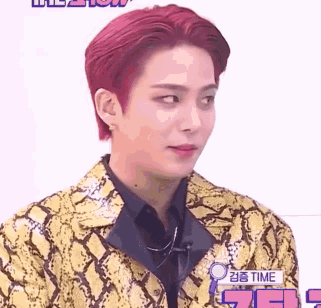 a man with red hair is wearing a yellow and black snakeskin jacket