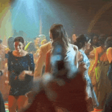 a group of people are dancing in a club and one of them is wearing a blue dress