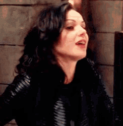 a woman in a black leather jacket is making a face .