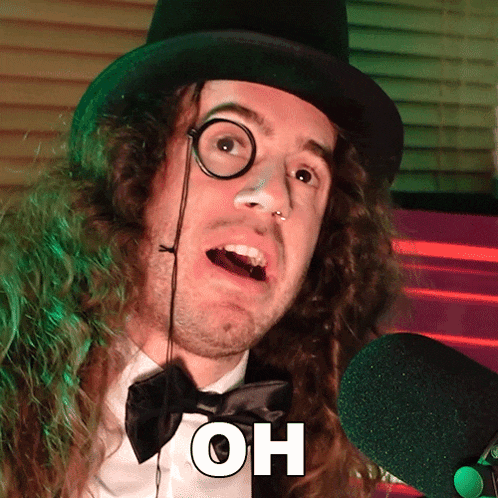 a man wearing a top hat and bow tie says " oh " in front of a microphone