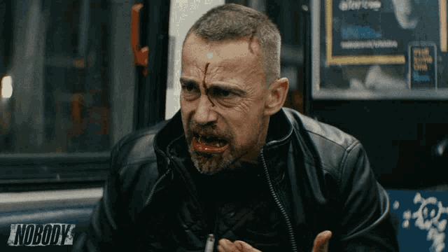 a man with blood on his face has the word nobody on his back