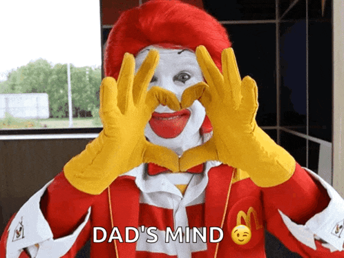 a mcdonald 's clown making a heart with his hands