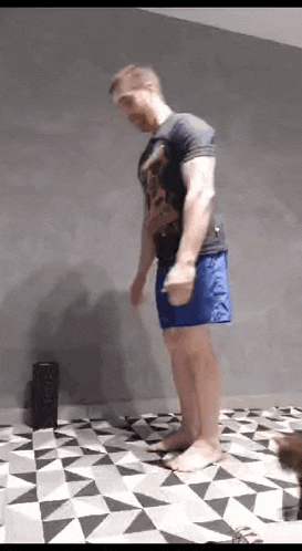 a man in blue shorts is jumping in the air .