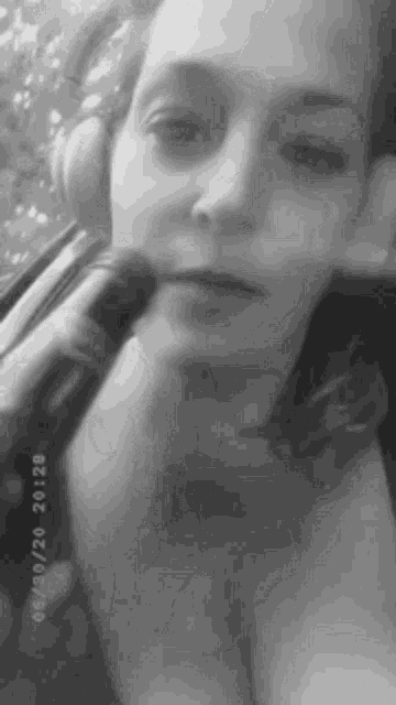 a black and white photo of a woman wearing headphones holding a microphone