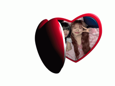 a heart shaped mirror shows two girls giving peace signs