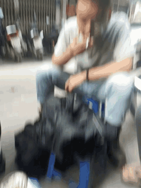 a blurry picture of a man sitting on a blue chair