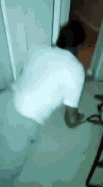 a person is squatting down in a bathroom next to a door .
