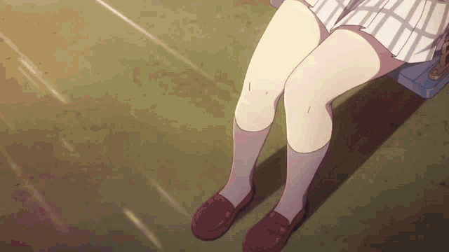 a girl is sitting on a bench with her legs crossed and her skirt visible