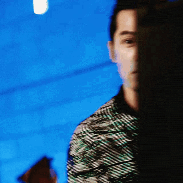 a blurry picture of a man 's face with a blue sky in the background