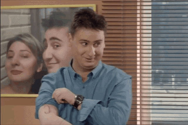 a man with a tattoo of the letter c on his arm looks at his watch