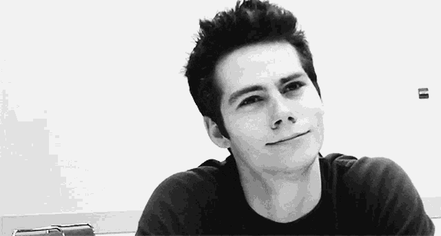 a black and white photo of a young man making a funny face .