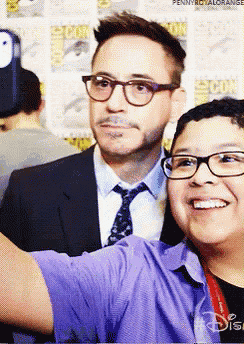 a man in a suit and tie takes a selfie with a young boy wearing glasses