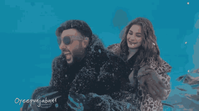 a man and a woman are playing in the snow with a blue background that says oyeepunjaban