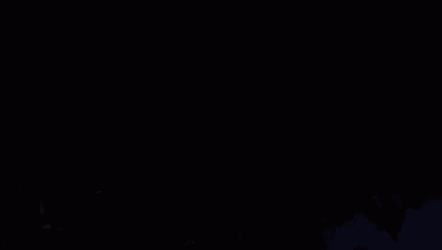 a crowd of people are dancing in a dark room at a concert