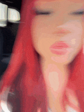 a blurry picture of a woman with red hair and her eyes closed