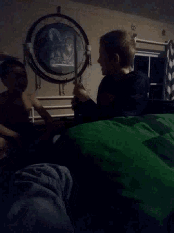 a couple of people are laying on a bed in a dark room