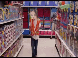 a little girl in a safety vest is walking down a toy aisle in a store