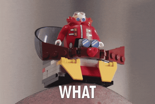 a lego figure is sitting on a piece of wood with the word what written below it