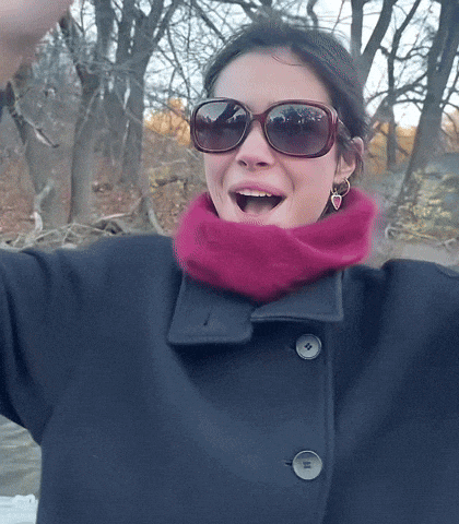 a woman wearing sunglasses and a scarf with a heart shaped earring