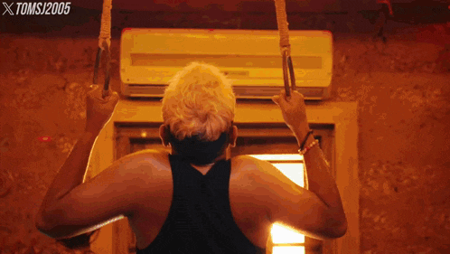 a man is doing exercises in front of an air conditioner and the year 2005 is on the bottom