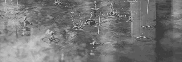 a black and white photo of rain drops falling into a puddle of water .