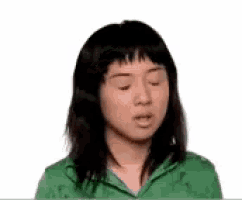 a young woman in a green shirt is making a funny face .