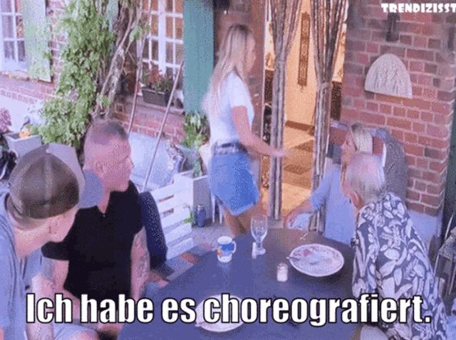 a group of people sitting around a table with ich habe es choreografiert
