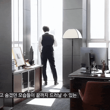 a man stands in front of a dell computer in an office