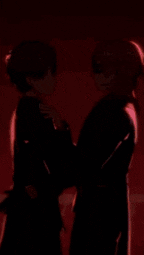 a couple of anime characters standing next to each other .