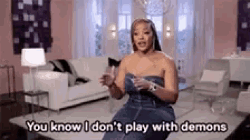 a woman is sitting in a living room and saying `` you know i don 't play with demons ''