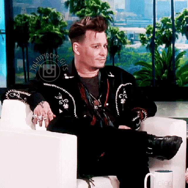 johnny depp is sitting in a chair with his legs crossed in front of a sign that says " johnnydepp gifs "